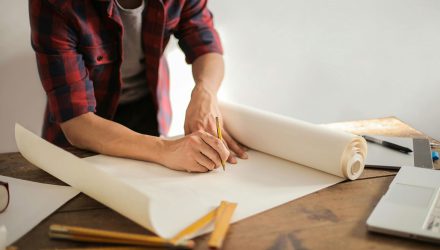 Man drawing building plans on paper