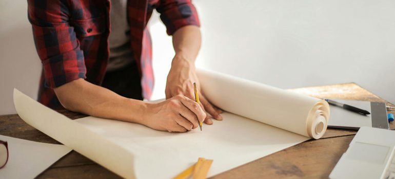 Man drawing building plans on paper